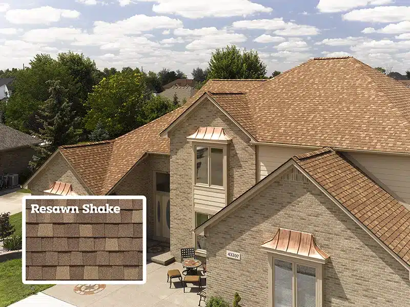 picture of a tan colored brick house with resawn shake golden shingles