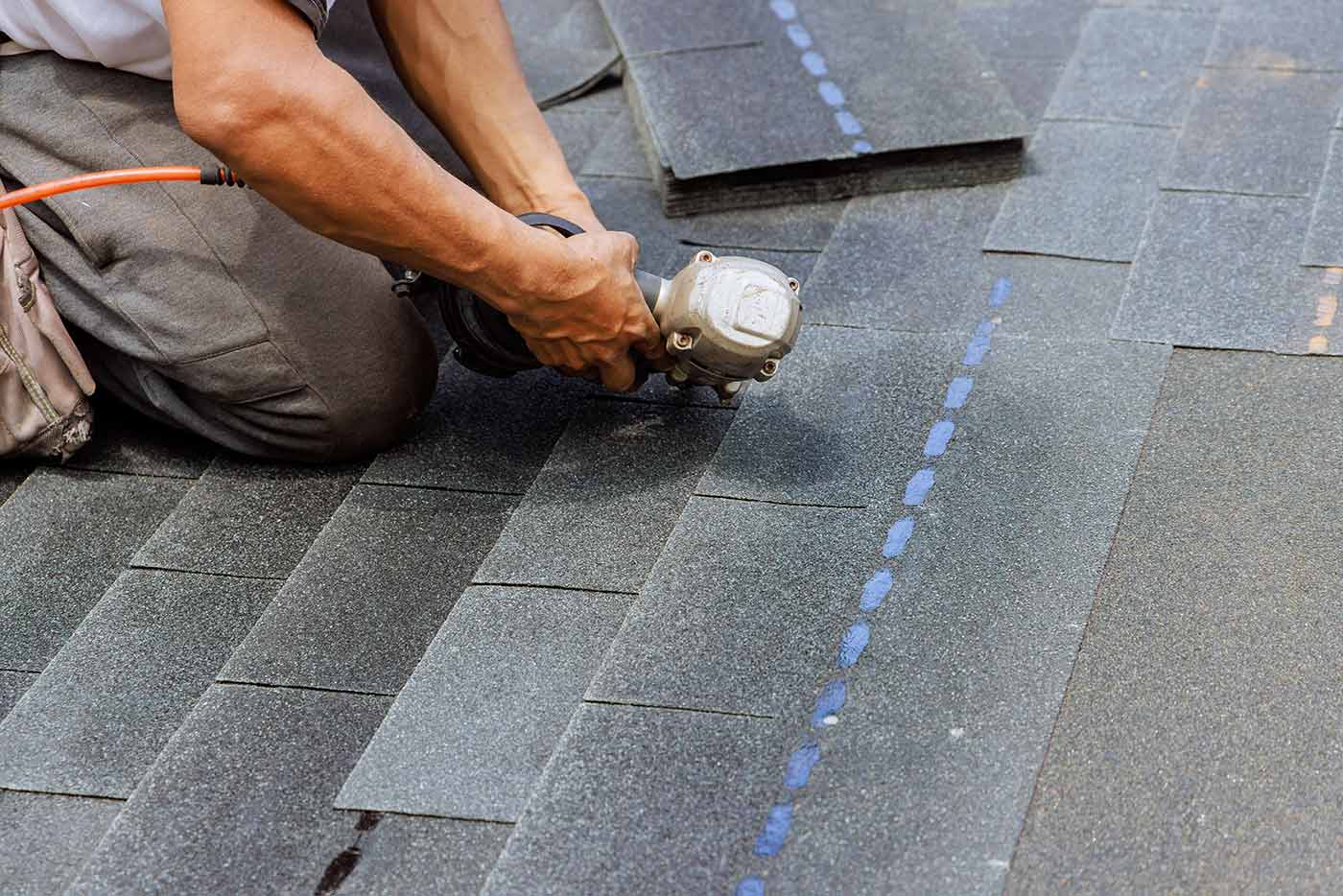 A roofer laying new shingles