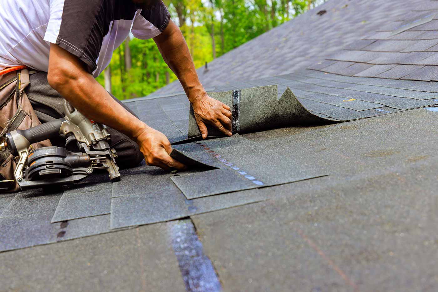 A construction worker laying down shingles